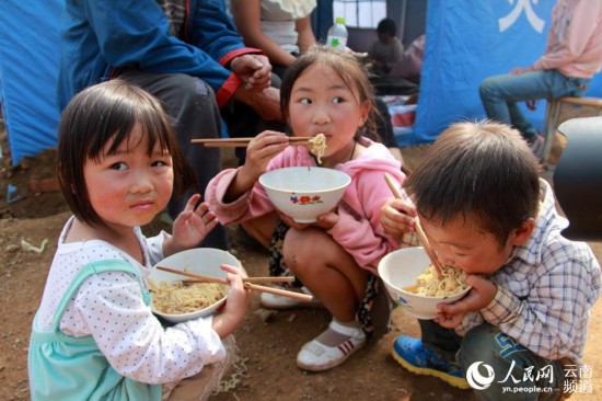 8月6日，灰街子临时安置点，三个孩子正在吃方便面。 （人民网虎遵会摄）
